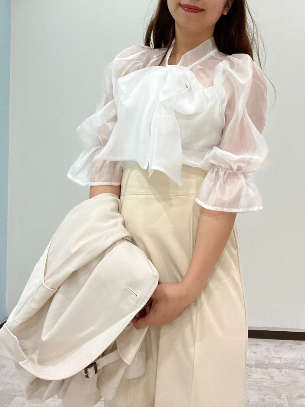 ホワイト系のシャツ/ブラウス、ホワイト系のトレンチコート、ベージュ系のショルダーバッグを着用したレディースの春コーディネートの3枚目の写真