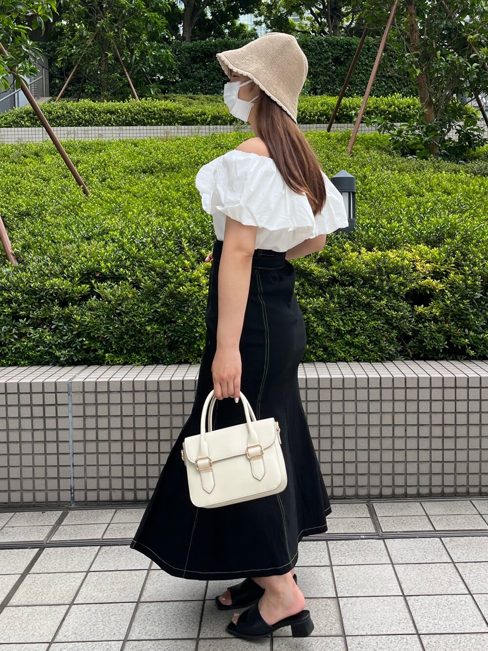 ホワイト系のショルダーバッグ、ホワイト系のシャツ/ブラウス、ブラック系のスカートを着用したレディースの夏コーディネートの4枚目の写真