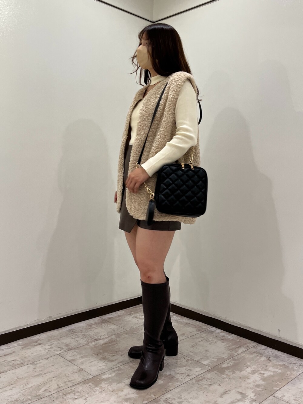 ホワイト系のカーディガン/ボレロ、ベージュ系のその他アウター、ブラック系のショルダーバッグを着用したレディースの秋コーディネートの2枚目の写真