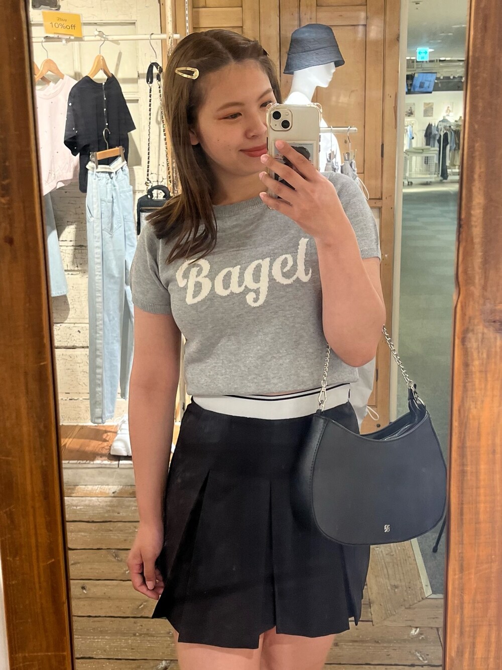 グレー系のニット/セーター、ブラック系のスカート、ブラック系のショルダーバッグを着用したレディースの夏コーディネートの2枚目の写真