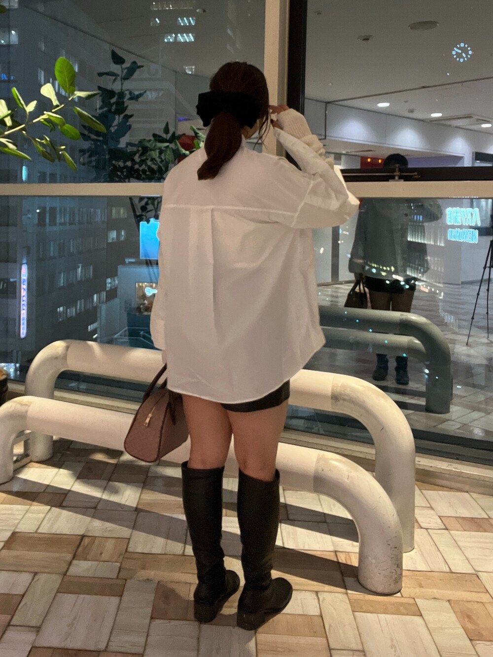 ホワイト系のシャツ/ブラウス、ブラック系のスカート、ブラック系のブーツを着用したレディースの秋コーディネートの2枚目の写真