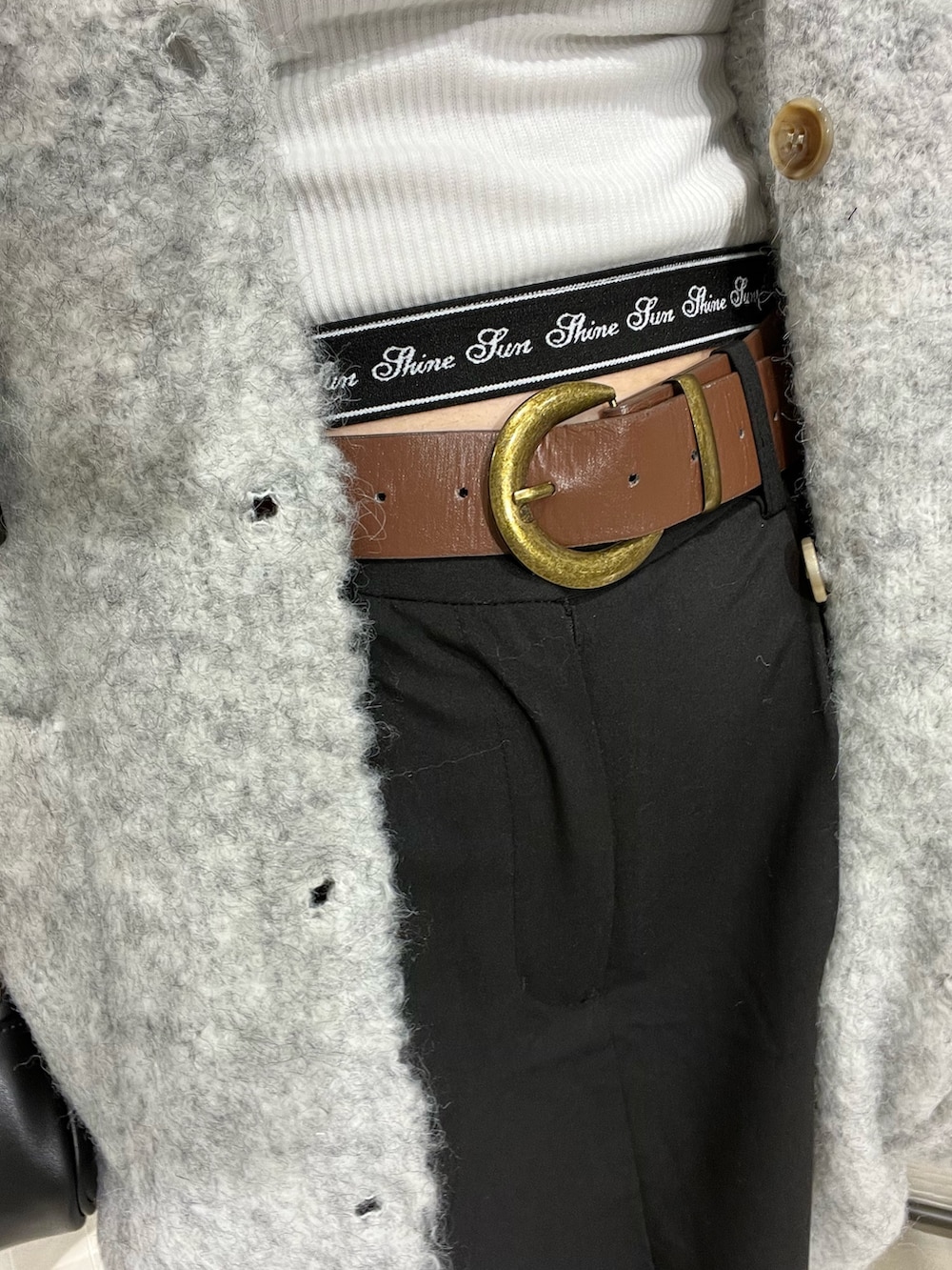 ブラック系のスカート、グレー系のカーディガン/ボレロ、ホワイト系のTシャツ/カットソーを着用したレディースの秋コーディネートの4枚目の写真