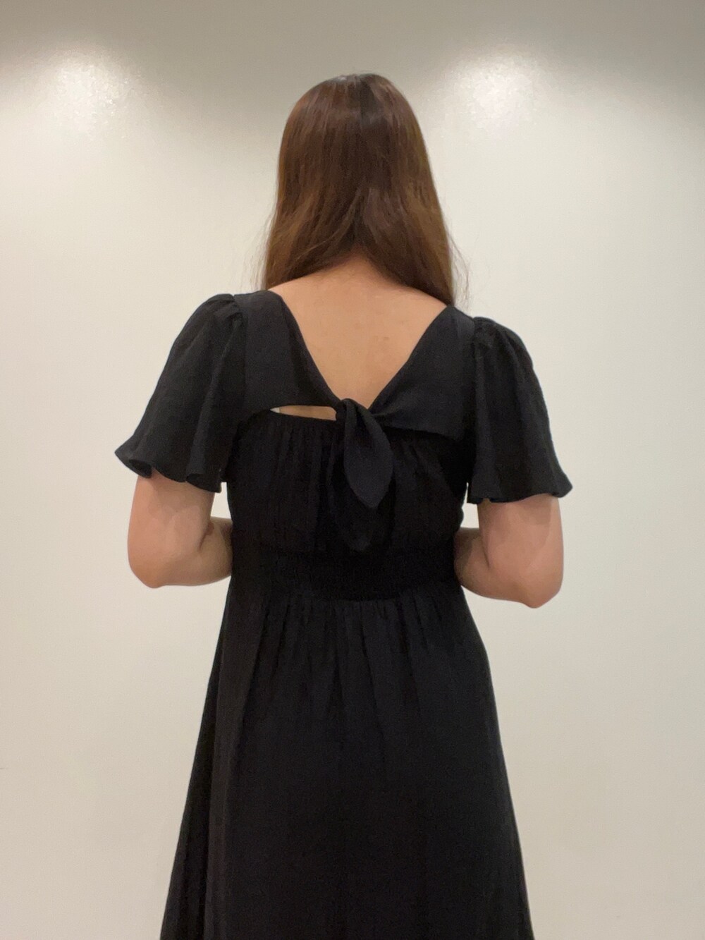 ホワイト系のショルダーバッグ、ブラック系のワンピース、ブラック系のサンダルを着用したレディースの夏コーディネートの3枚目の写真