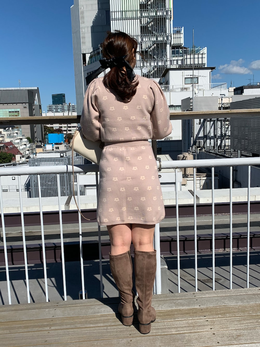 ベージュ系のワンピース、ホワイト系のショルダーバッグ、ベージュ系のブーツを着用したレディースの秋コーディネートの2枚目の写真