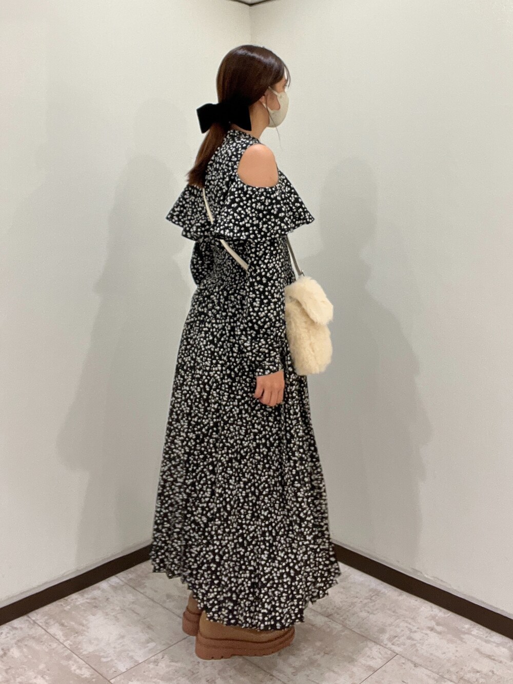 ブラック系のワンピース、イエロー系のブーツを着用したレディースの秋コーディネートの2枚目の写真