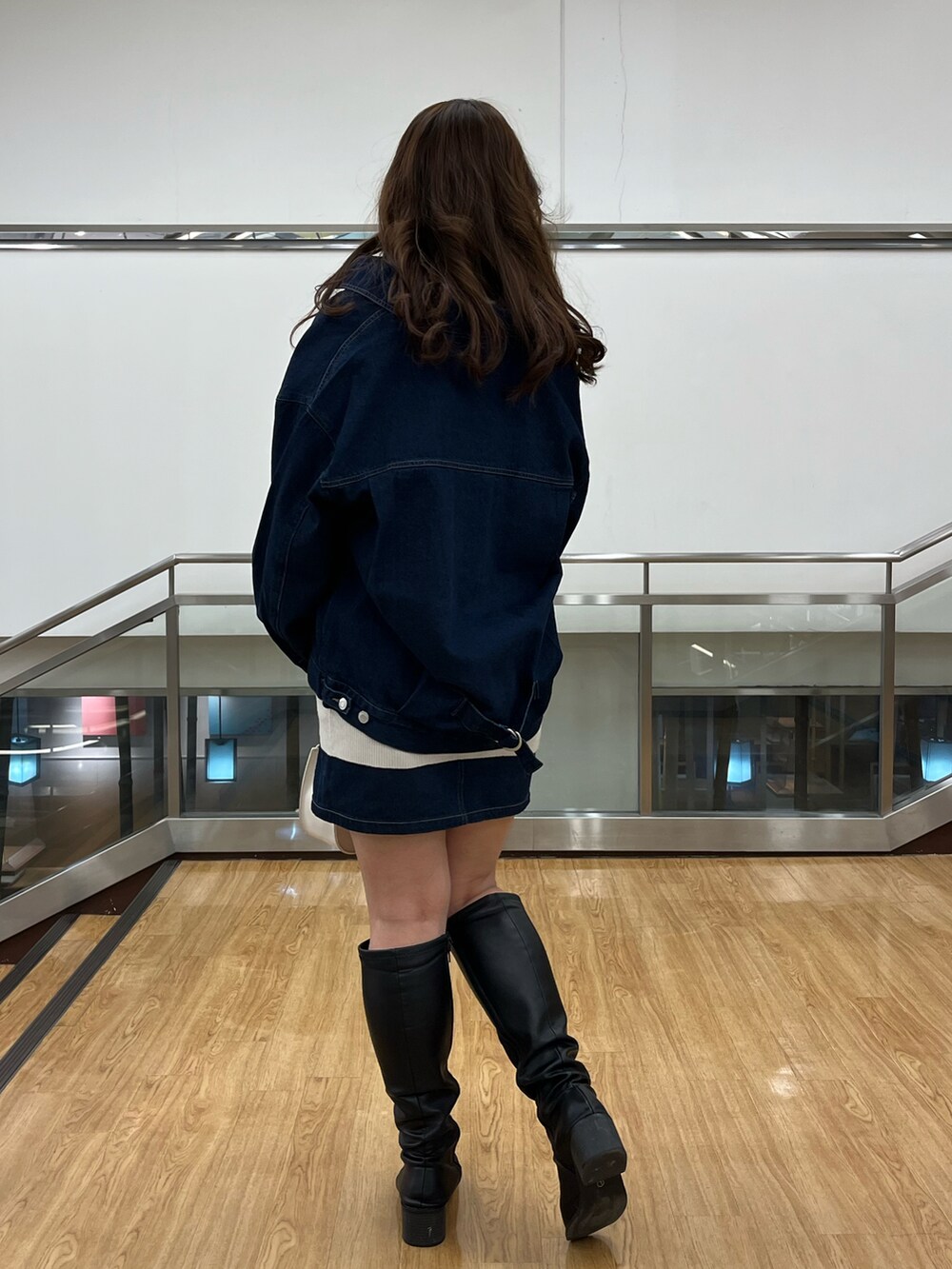 ブルー系のデニムジャケット、ブルー系のデニムジャケット、グレー系のベストを着用したレディースの冬コーディネートの3枚目の写真