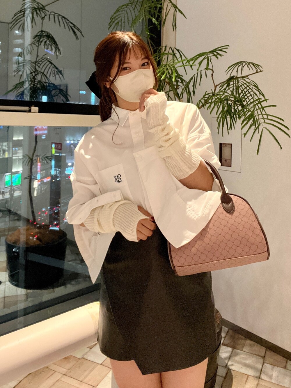 ブラック系のスカート、ブラウン系のボストンバッグ、ホワイト系のシャツ/ブラウスを着用したレディースの秋コーディネートの3枚目の写真