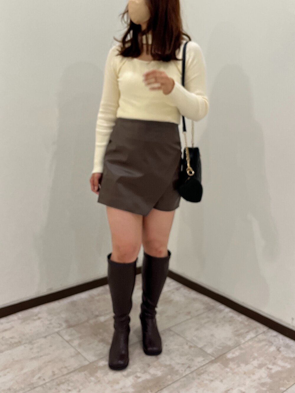 ホワイト系のニット/セーター、ブラウン系のスカート、ブラック系のショルダーバッグを着用したレディースの秋コーディネートの5枚目の写真