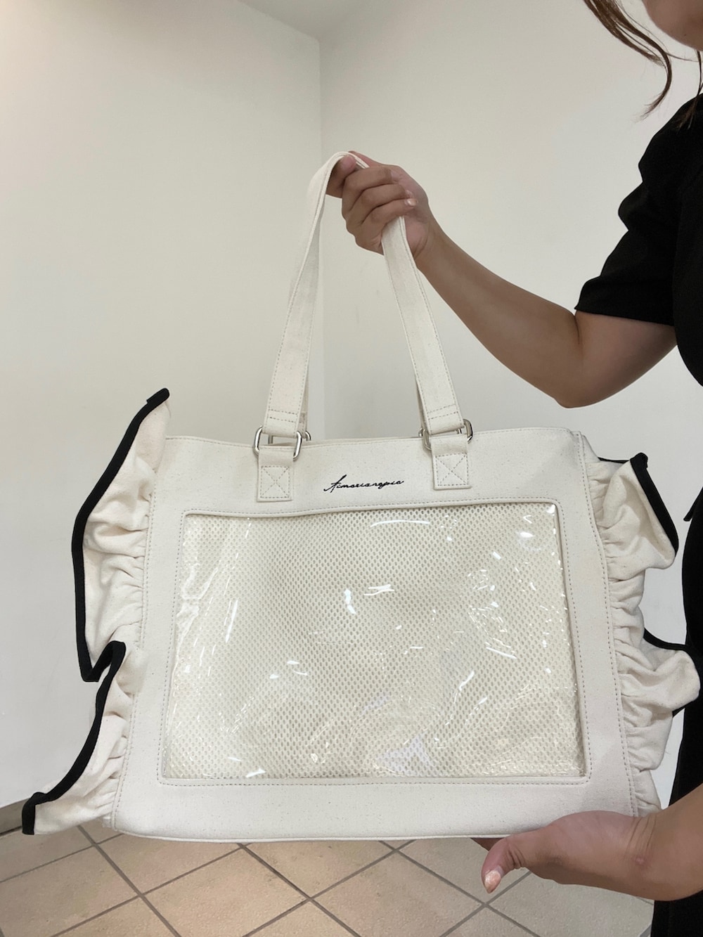 ホワイト系のトートバッグを着用したレディースの秋コーディネートの2枚目の写真