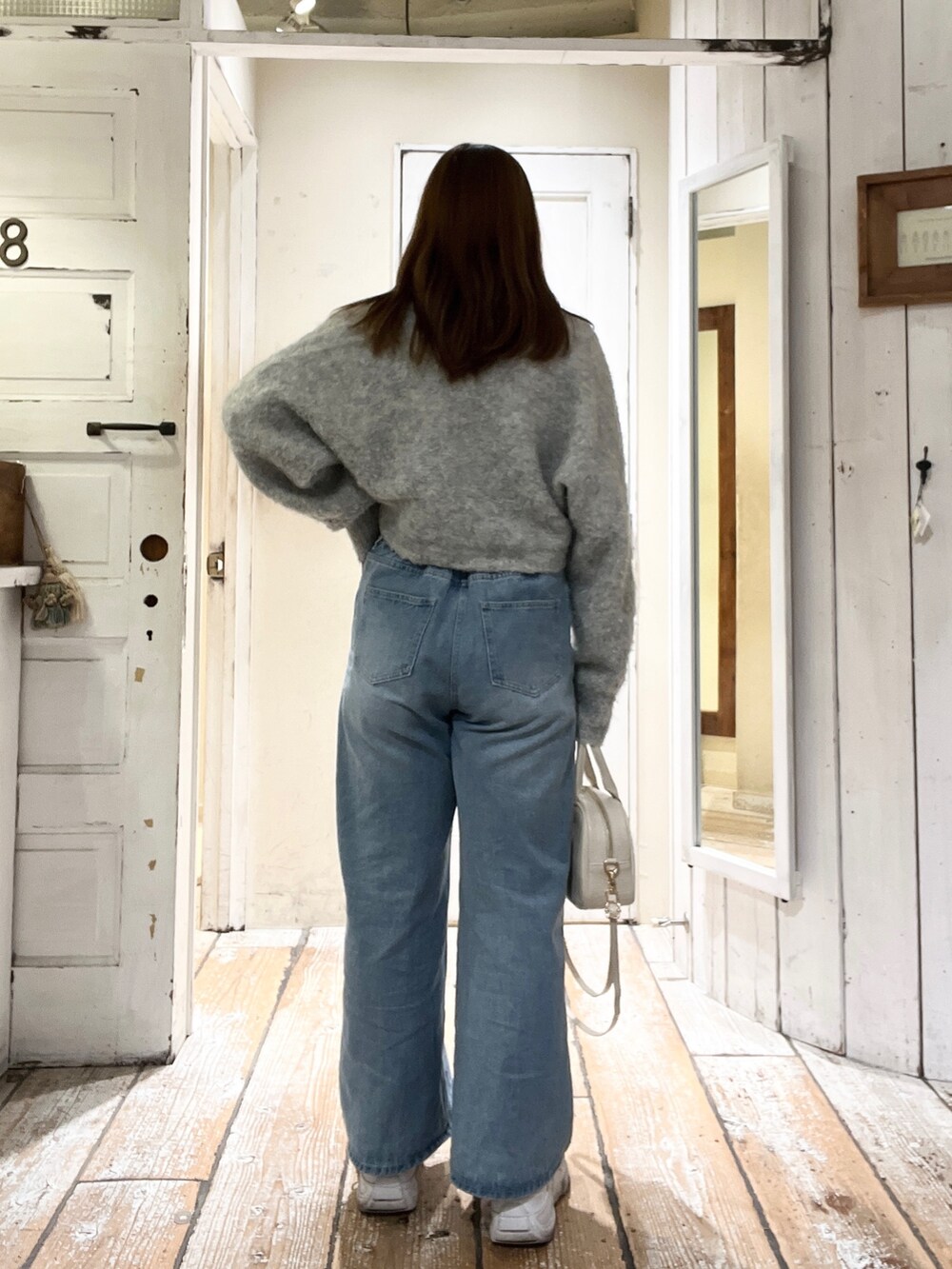 ベージュ系のカーディガン/ボレロ、ブルー系のデニムパンツを着用したレディースの秋コーディネートの3枚目の写真