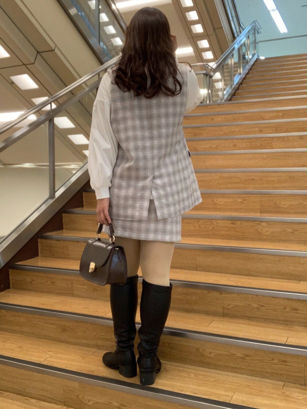 グレー系のその他アウター、グレー系のスカート、ブラウン系のショルダーバッグを着用したレディースの冬コーディネートの2枚目の写真