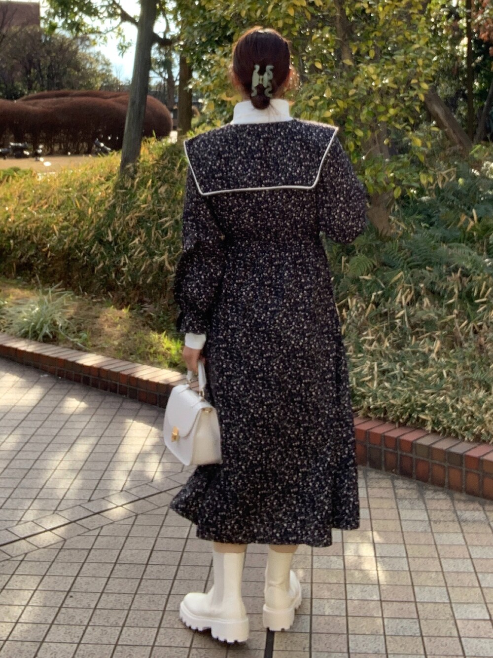 ホワイト系のTシャツ/カットソー、ブラック系のワンピース、ホワイト系のショルダーバッグを着用したレディースの冬コーディネートの2枚目の写真