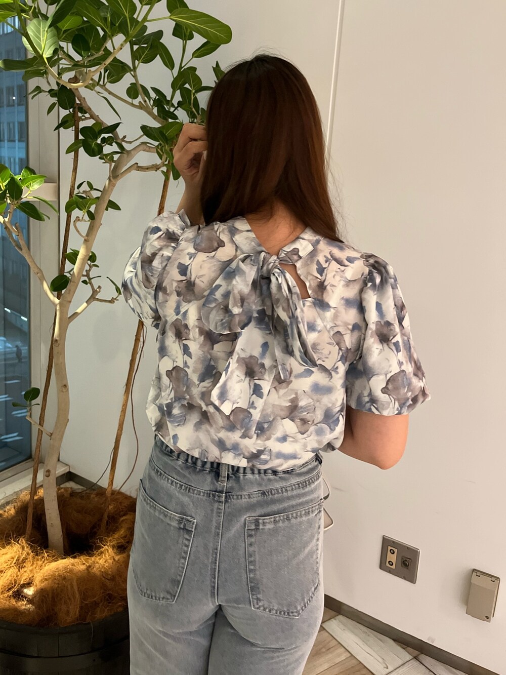 グレー系のシャツ/ブラウス、ブルー系のデニムパンツ、シルバー系のショルダーバッグを着用したレディースの夏コーディネートの2枚目の写真