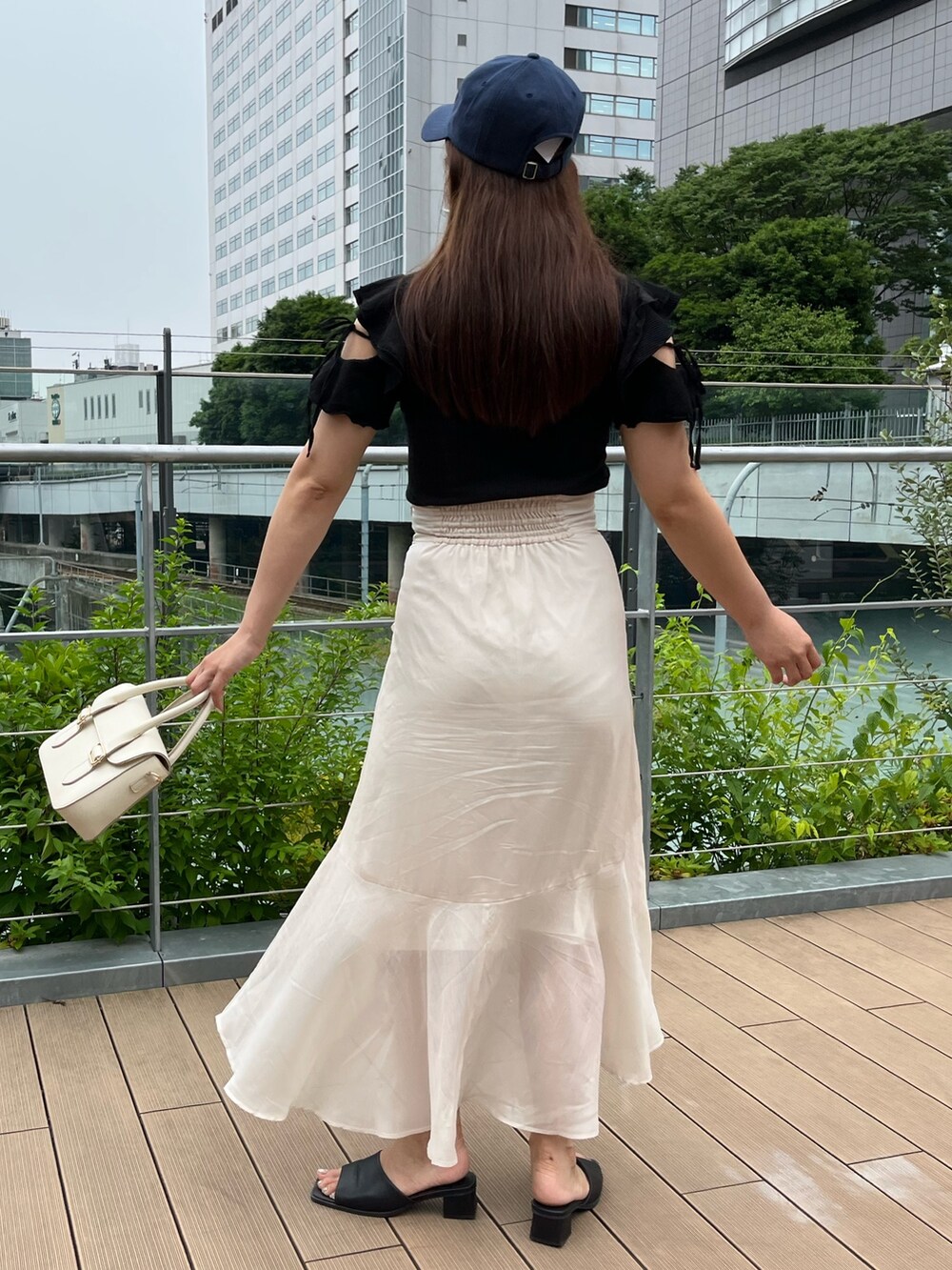 ブラック系のTシャツ/カットソー、ホワイト系のショルダーバッグ、ベージュ系のスカートを着用したレディースの夏コーディネートの2枚目の写真