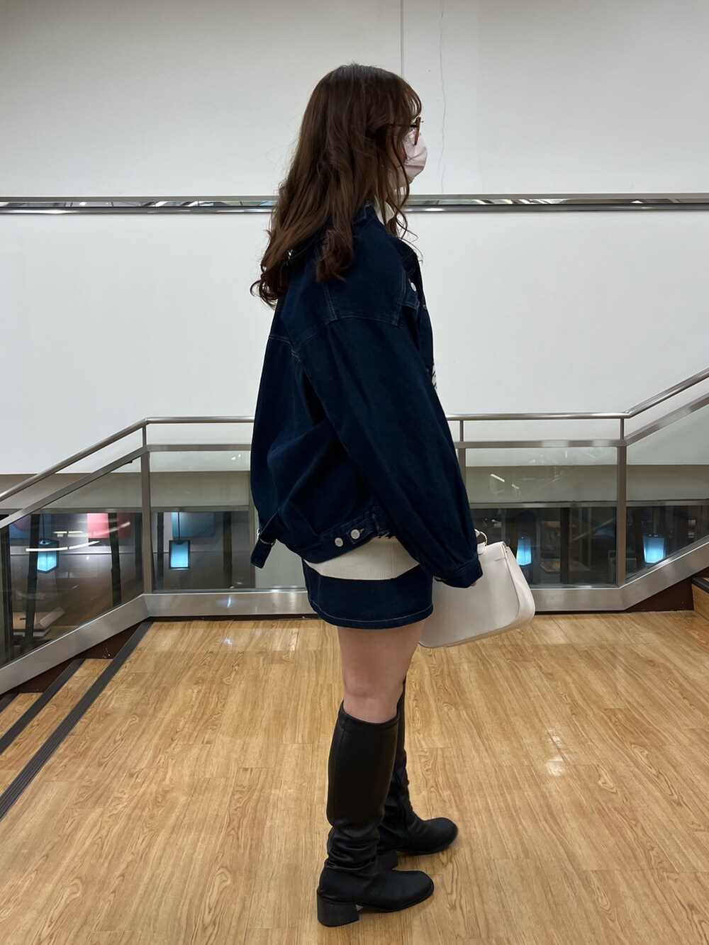 ブルー系のデニムジャケット、ブルー系のデニムジャケット、グレー系のベストを着用したレディースの冬コーディネートの2枚目の写真