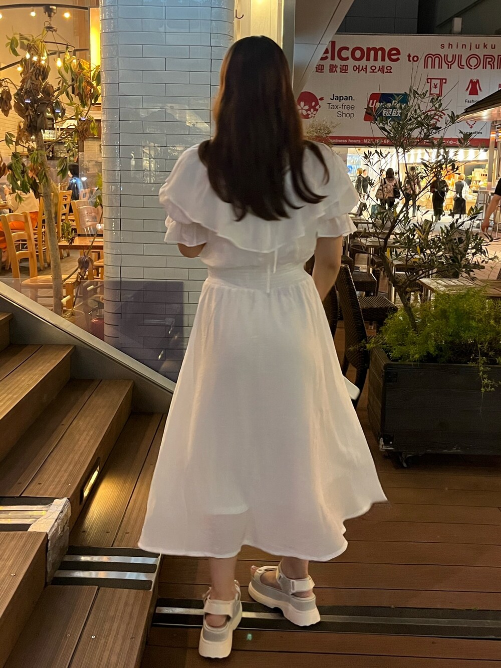 ホワイト系のワンピース、ホワイト系のショルダーバッグ、ホワイト系のサンダルを着用したレディースの夏コーディネートの4枚目の写真