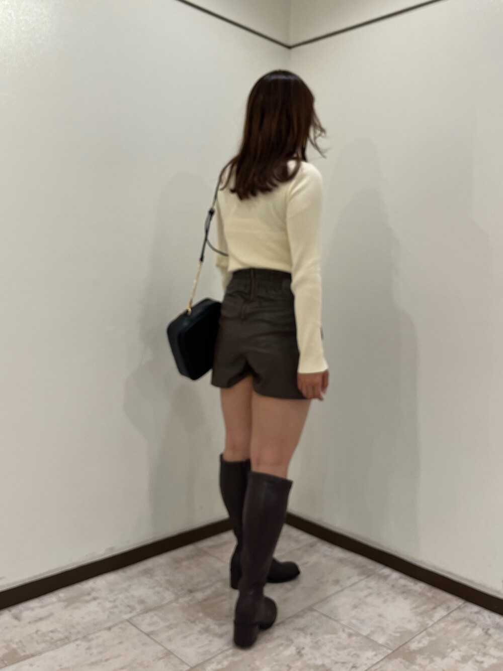 ホワイト系のニット/セーター、ブラウン系のスカート、ブラック系のショルダーバッグを着用したレディースの秋コーディネートの3枚目の写真