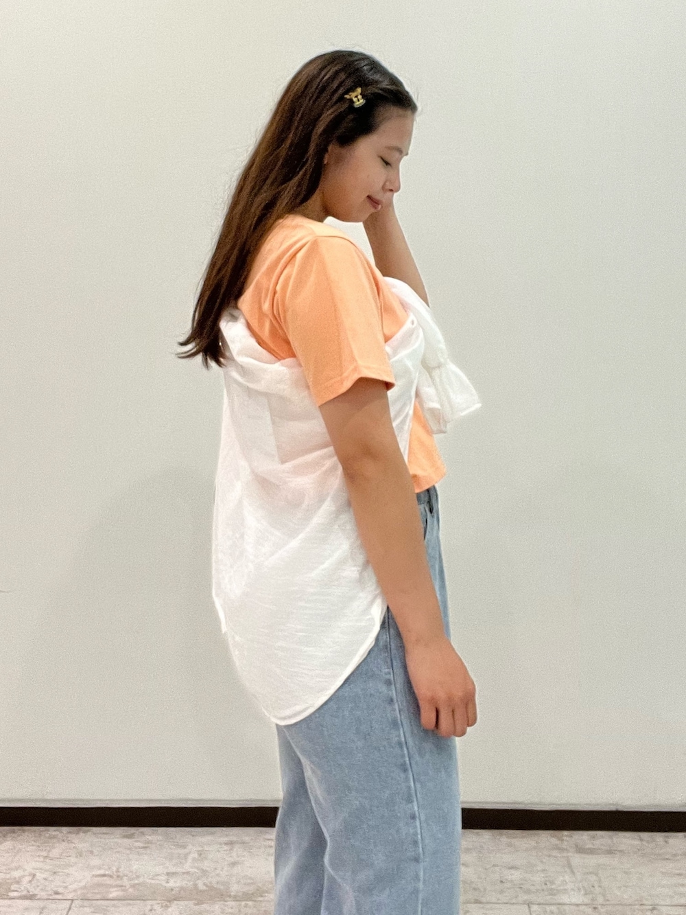 オレンジ系のTシャツ/カットソー、ホワイト系のシャツ/ブラウス、ブルー系のデニムパンツを着用したレディースの夏コーディネートの2枚目の写真