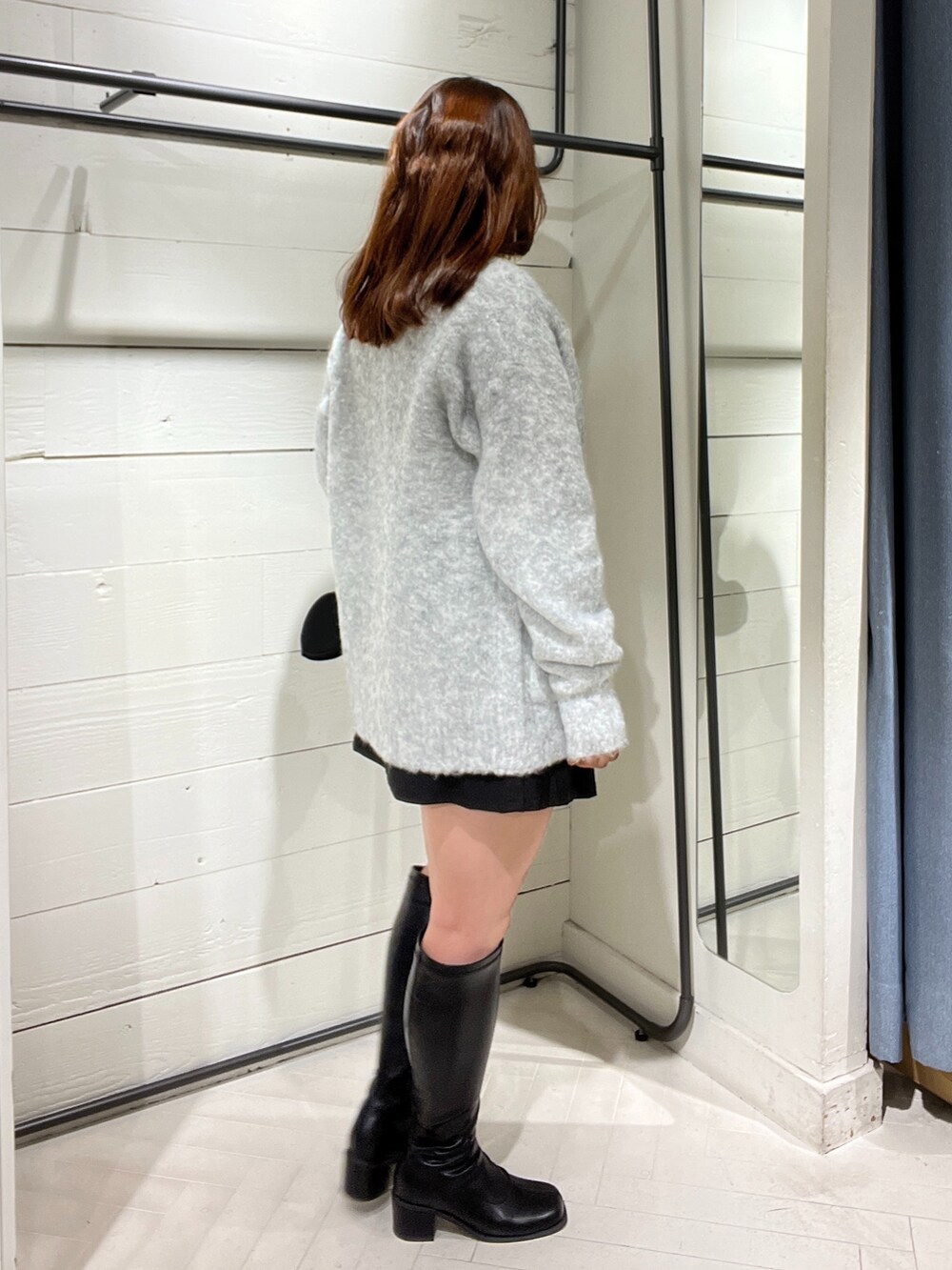 ブラック系のスカート、グレー系のカーディガン/ボレロ、ホワイト系のTシャツ/カットソーを着用したレディースの秋コーディネートの2枚目の写真