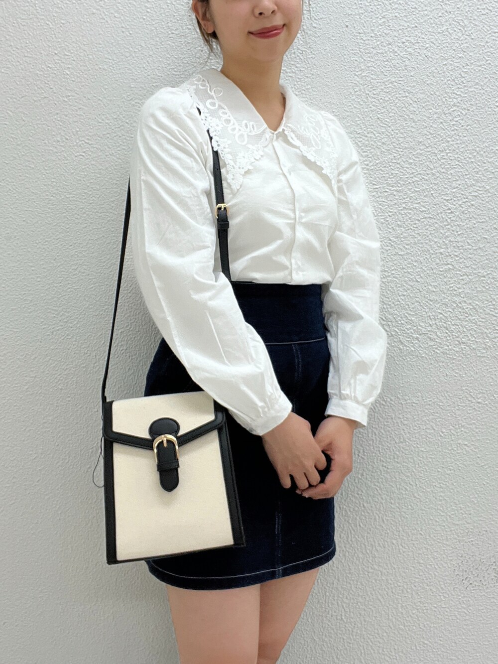 ホワイト系のシャツ/ブラウス、ブラック系のショルダーバッグ、ブルー系のスカートを着用したレディースの冬コーディネートの4枚目の写真