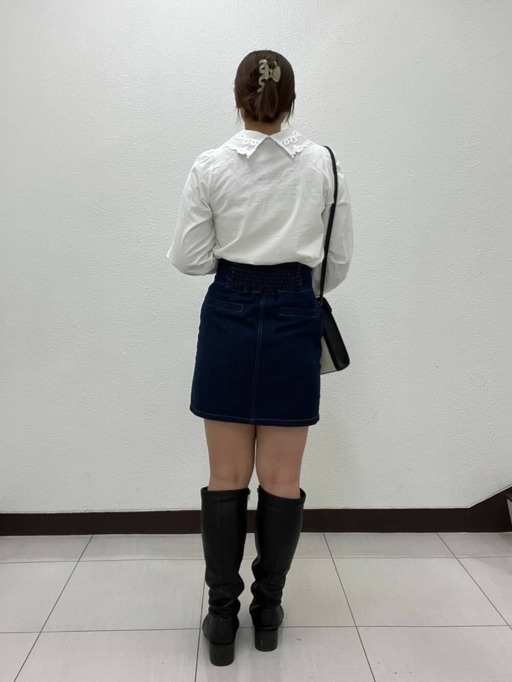 ホワイト系のシャツ/ブラウス、ブラック系のショルダーバッグ、ブルー系のスカートを着用したレディースの冬コーディネートの2枚目の写真