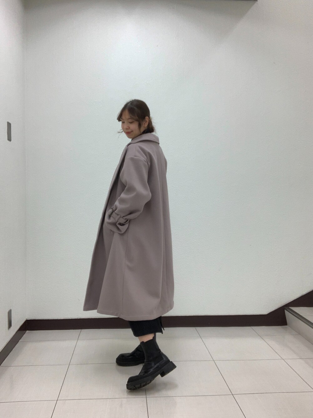 ホワイト系のカーディガン/ボレロ、ブラック系のスカート、ベージュ系のショルダーバッグを着用したレディースの冬コーディネートの3枚目の写真