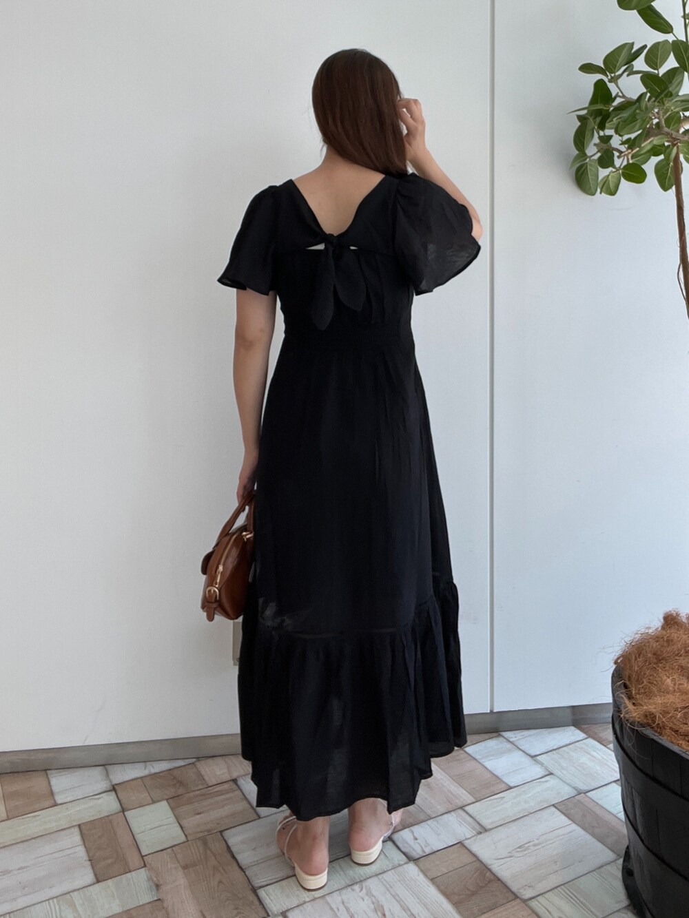 ブラウン系のワンピース、イエロー系のショルダーバッグ、ホワイト系のサンダルを着用したレディースの夏コーディネートの2枚目の写真