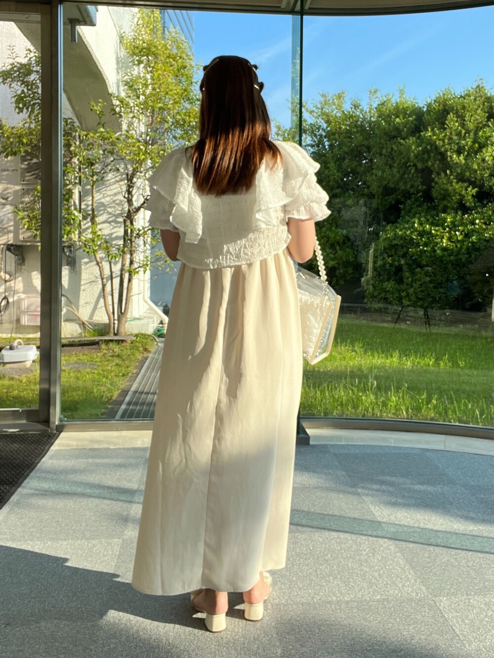 ホワイト系のワンピース、ホワイト系のショルダーバッグを着用したレディースの春コーディネートの2枚目の写真