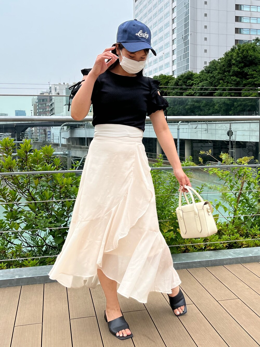 ブラック系のTシャツ/カットソー、ホワイト系のショルダーバッグ、ベージュ系のスカートを着用したレディースの夏コーディネートの4枚目の写真