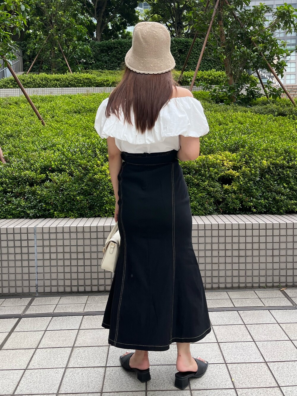 ホワイト系のショルダーバッグ、ホワイト系のシャツ/ブラウス、ブラック系のスカートを着用したレディースの夏コーディネートの3枚目の写真