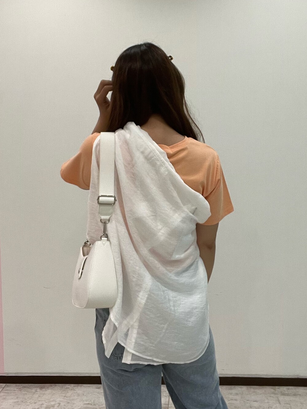 オレンジ系のTシャツ/カットソー、ホワイト系のシャツ/ブラウス、ブルー系のデニムパンツを着用したレディースの夏コーディネートの3枚目の写真