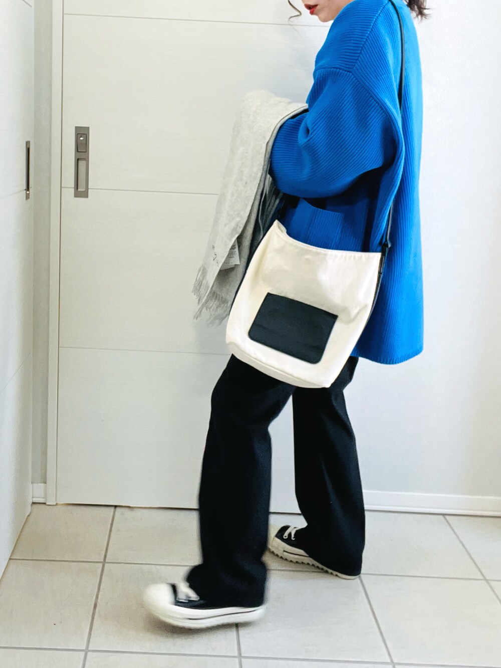 ブルー系のカーディガン/ボレロ、ホワイト系のTシャツ/カットソー、ブラック系のスラックスを着用したレディースの春コーディネートの5枚目の写真