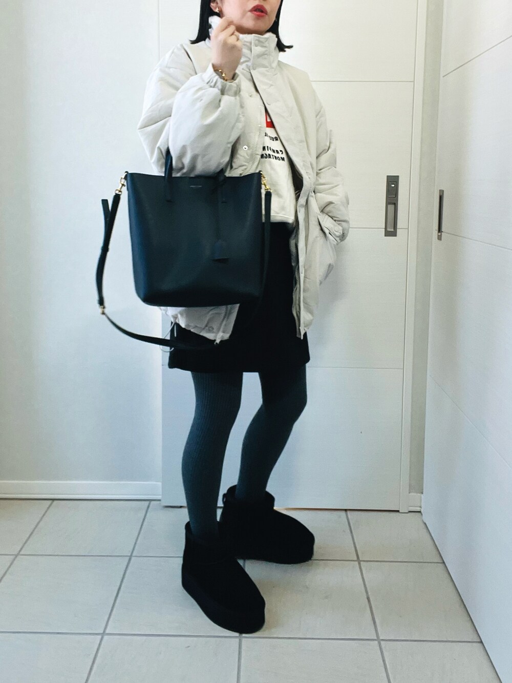 ホワイト系のブルゾン、ベージュ系のスウェット、ブラック系のその他パンツを着用したレディースの冬コーディネートの3枚目の写真