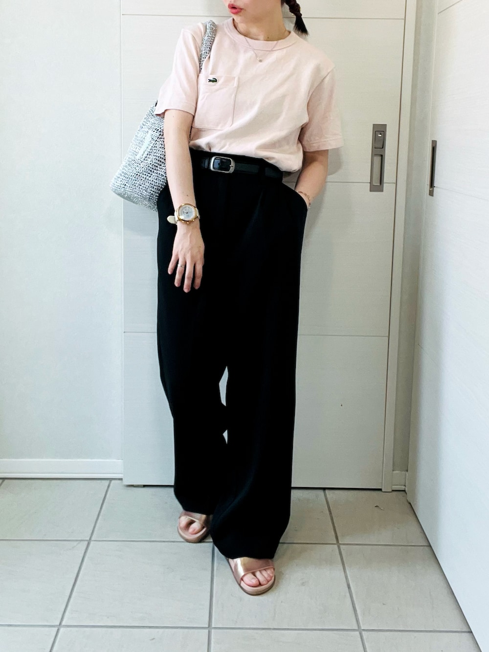 ブラック系のスラックス、ピンク系のTシャツ/カットソー、シルバー系のショルダーバッグを着用したレディースの夏コーディネートの4枚目の写真