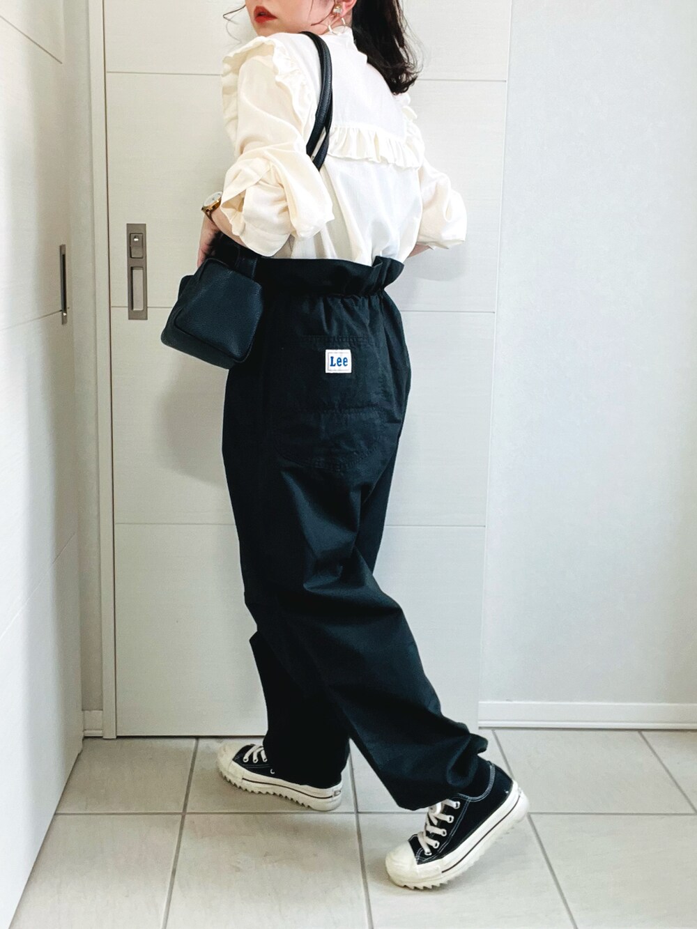ブラック系のカーゴパンツ、ホワイト系のシャツ/ブラウス、ブラック系のスニーカーを着用したレディースの春コーディネートの3枚目の写真