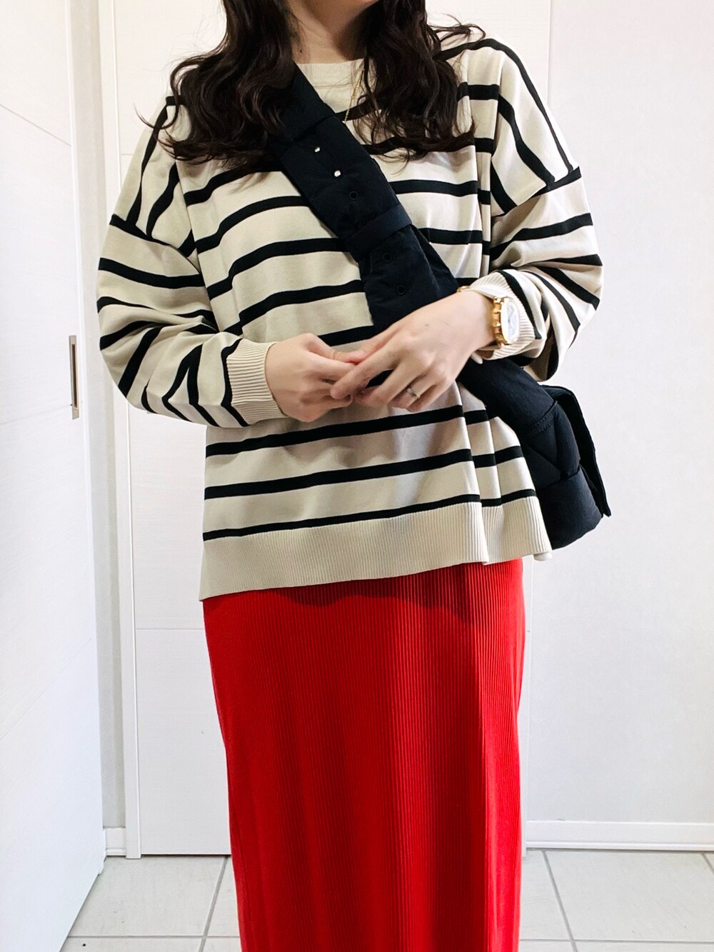 ホワイト系のニット/セーター、オレンジ系のスカート、ブラック系のローファーを着用したレディースの秋コーディネートの2枚目の写真