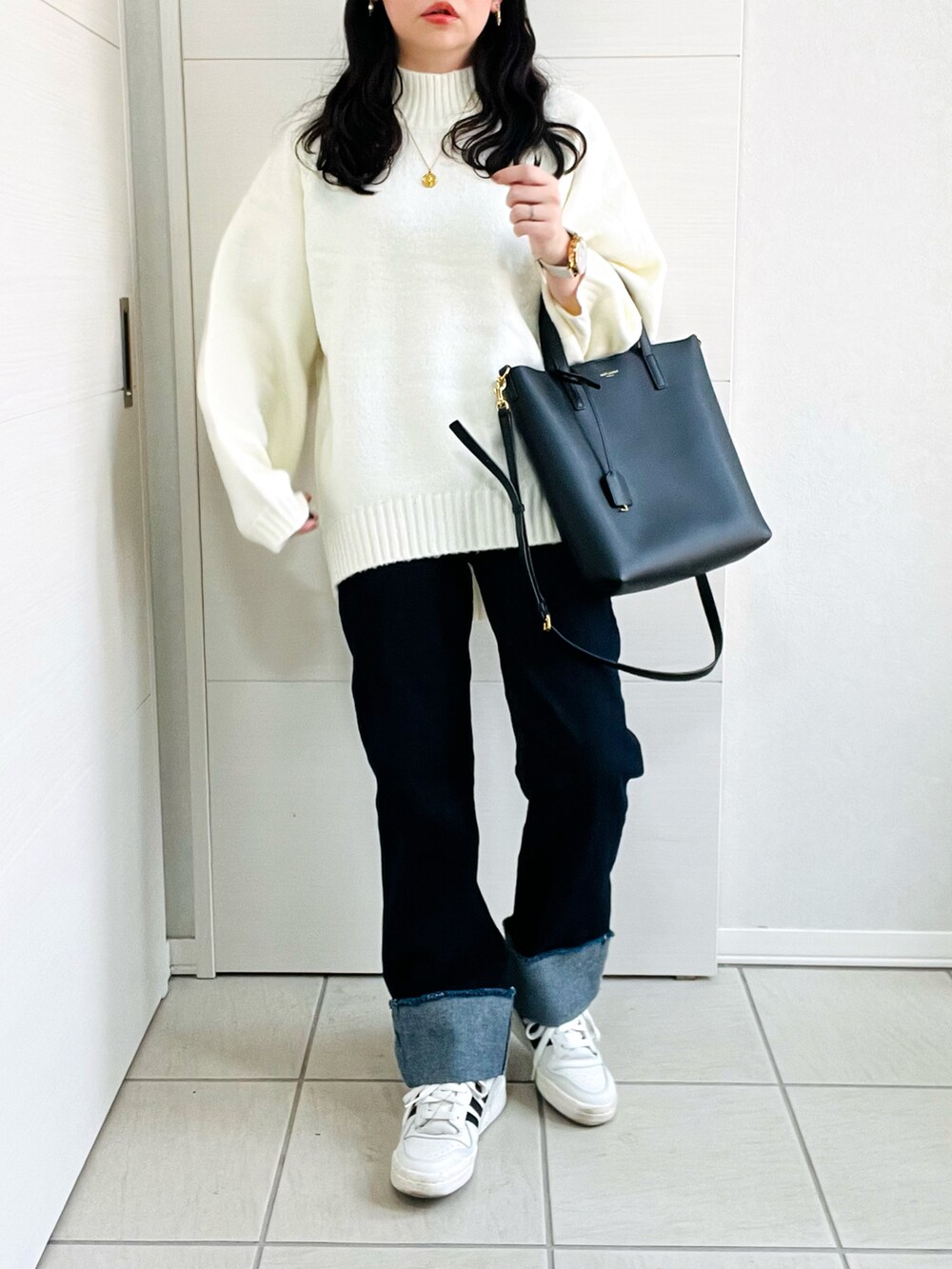 ホワイト系のニット/セーター、ブルー系のデニムパンツ、グレー系のスニーカーを着用したレディースの秋コーディネートの5枚目の写真