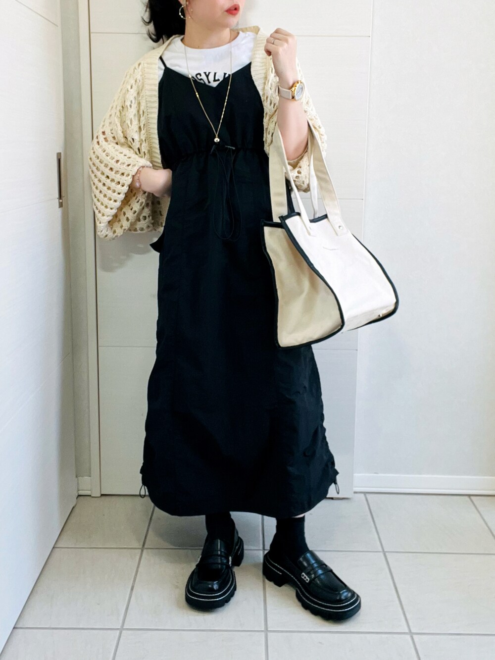 ホワイト系のカーディガン/ボレロ、ホワイト系のTシャツ/カットソー、ブラック系のワンピースを着用したレディースの春コーディネートの3枚目の写真
