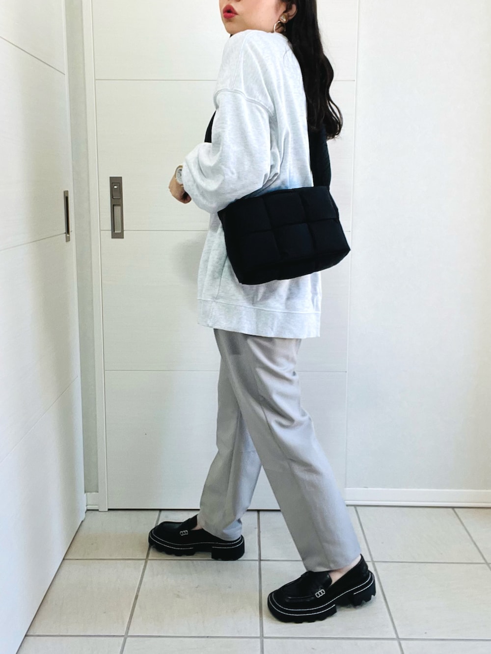 グレー系のスウェット、シルバー系のその他パンツ、ブラック系のローファーを着用したレディースの秋コーディネートの4枚目の写真