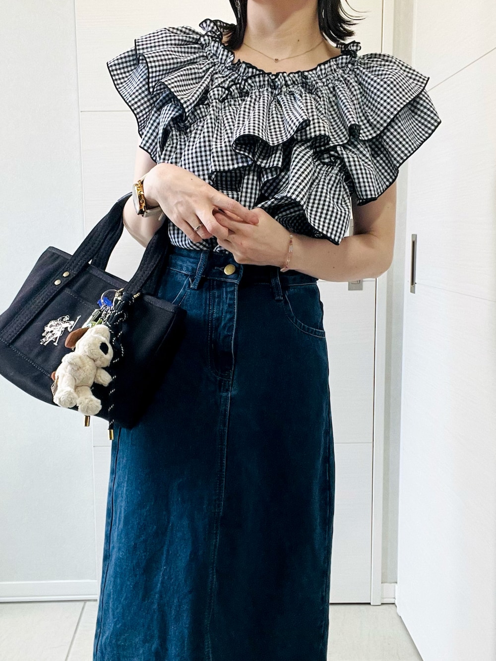 ブラック系のシャツ/ブラウス、ブルー系のデニムスカート、ブラック系のローファーを着用したレディースの春コーディネートの2枚目の写真