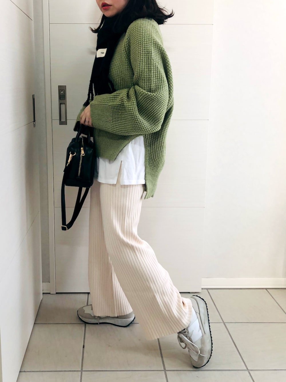 グリーン系のニット/セーター、ホワイト系のその他パンツ、ホワイト系のスニーカーを着用したレディースの冬コーディネートの3枚目の写真