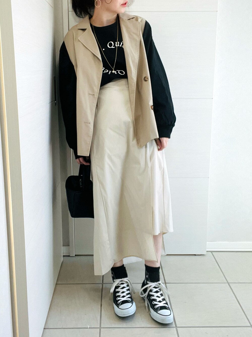 ブラック系のTシャツ/カットソー、ベージュ系のテーラードジャケット、ベージュ系のスカートを着用したレディースの冬コーディネートの2枚目の写真