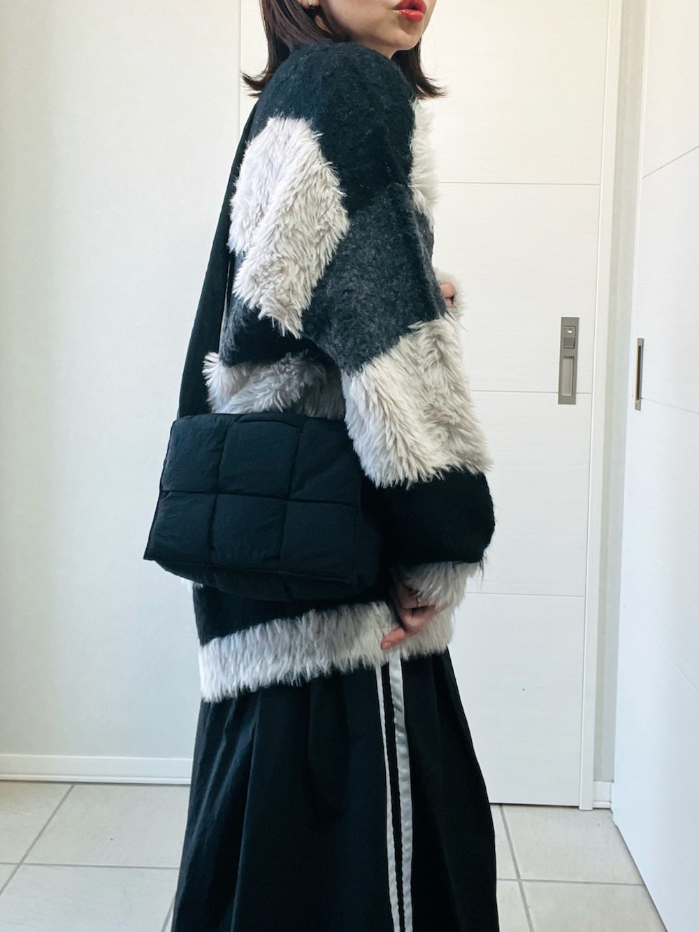 ブラック系のカーディガン/ボレロ、ブラック系のスニーカー、ブラック系のスカートを着用したレディースの秋コーディネートの3枚目の写真