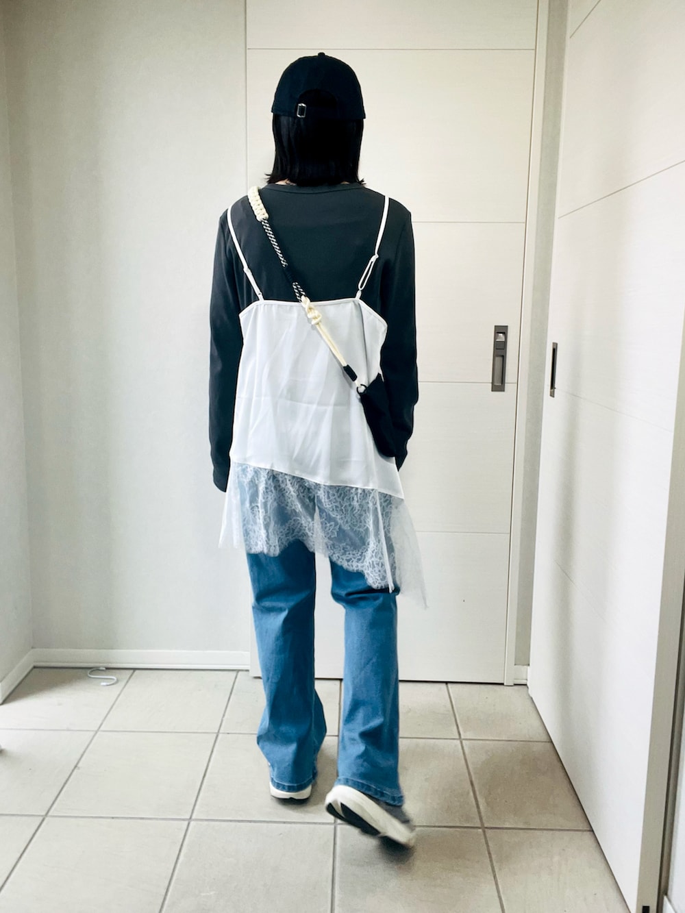 ホワイト系のキャミソール、グレー系のTシャツ/カットソー、ブルー系のデニムパンツを着用したレディースの春コーディネートの3枚目の写真