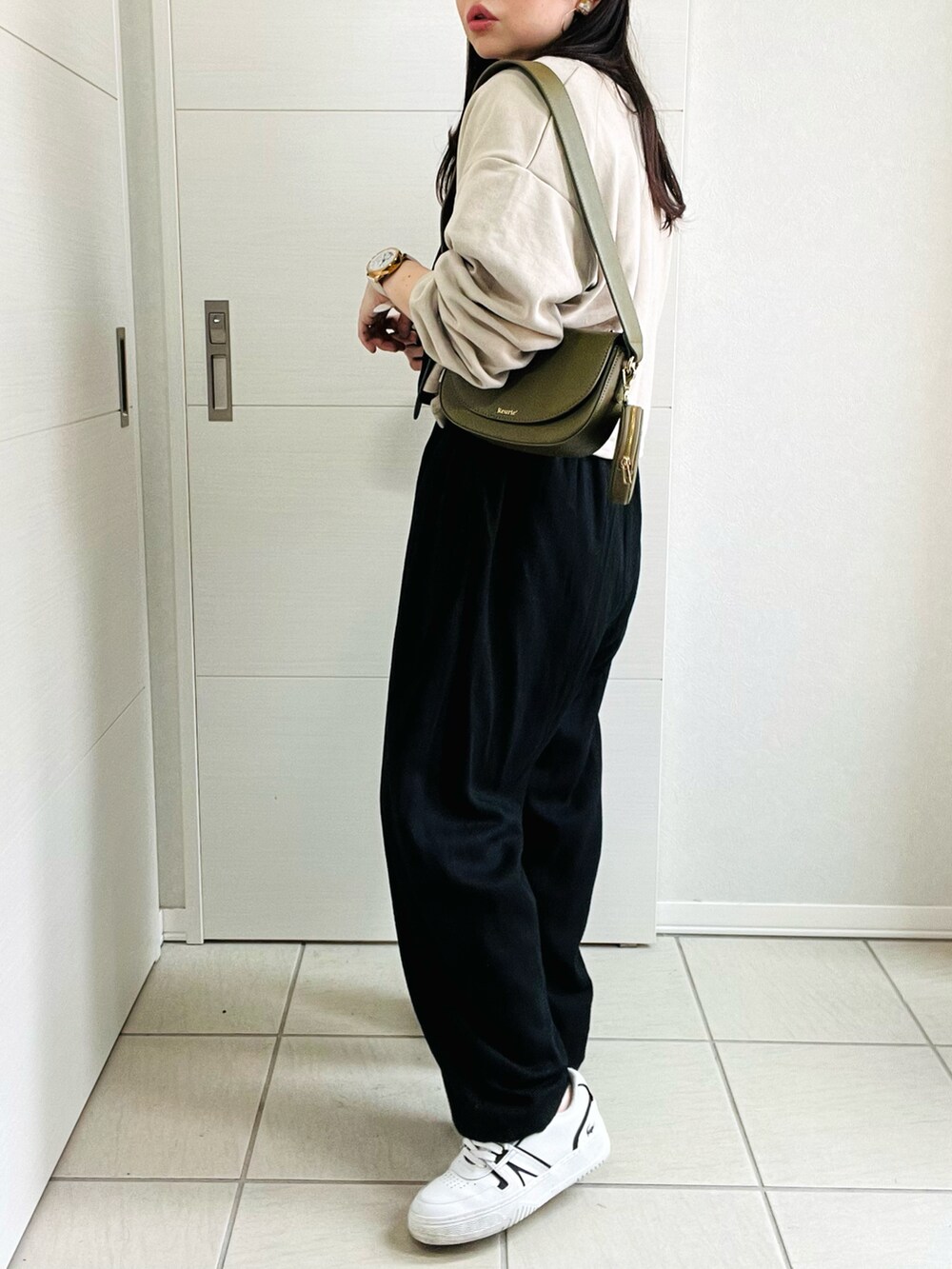 ブラック系のサロペット/オーバーオール、ベージュ系のカーディガン/ボレロ、ホワイト系のスニーカーを着用したレディースの夏コーディネートの5枚目の写真