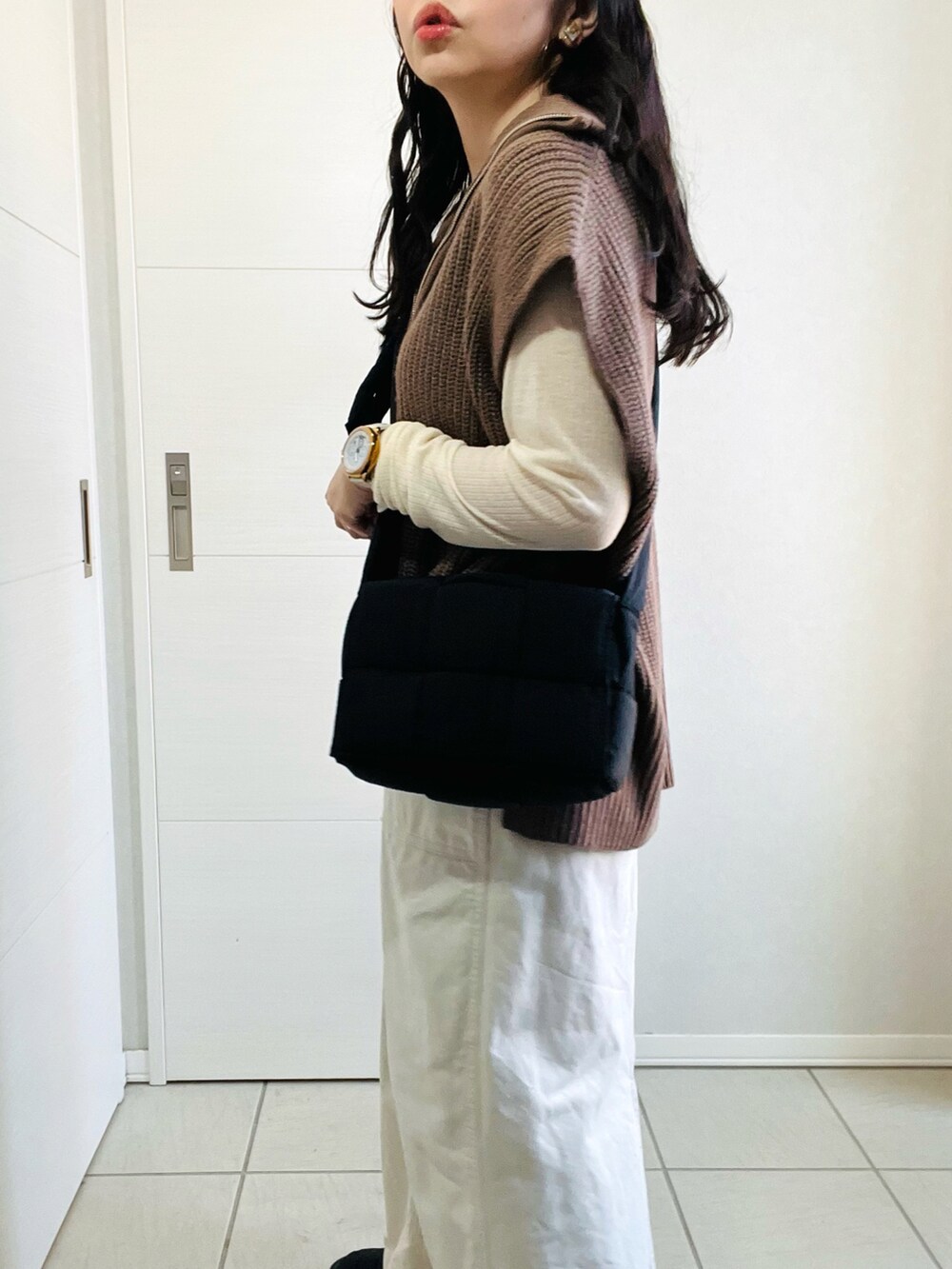 ブラウン系のベスト、ホワイト系のTシャツ/カットソー、ホワイト系のスカートを着用したレディースの秋コーディネートの4枚目の写真