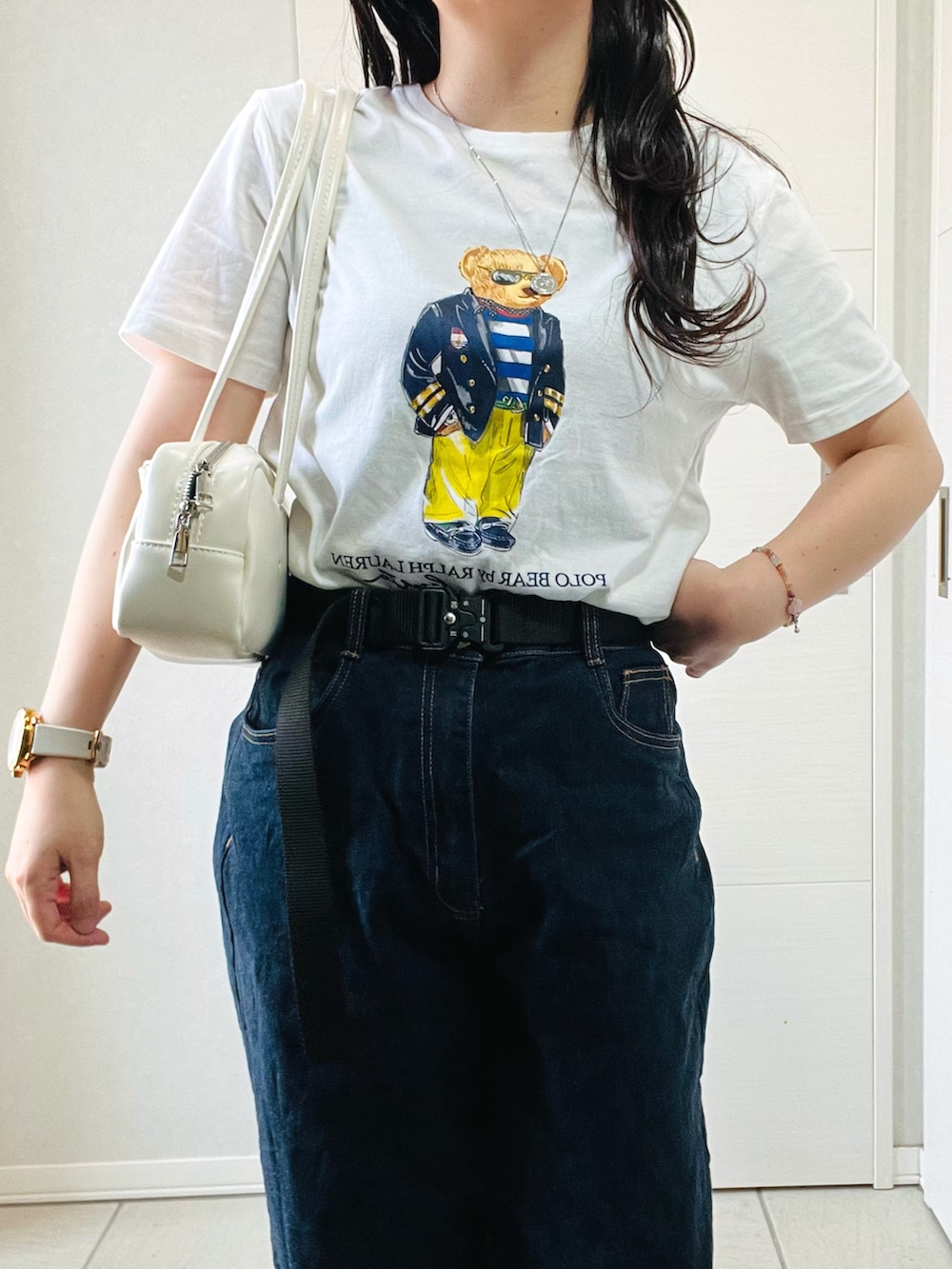 ホワイト系のTシャツ/カットソー、ブルー系のデニムパンツ、ブラック系のスニーカーを着用したレディースの夏コーディネートの2枚目の写真