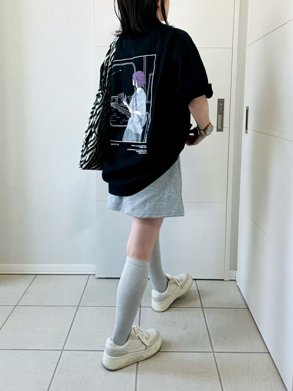 ブラック系のTシャツ/カットソー、ホワイト系のスニーカー、ブラック系のトートバッグを着用したレディースの春コーディネートの4枚目の写真