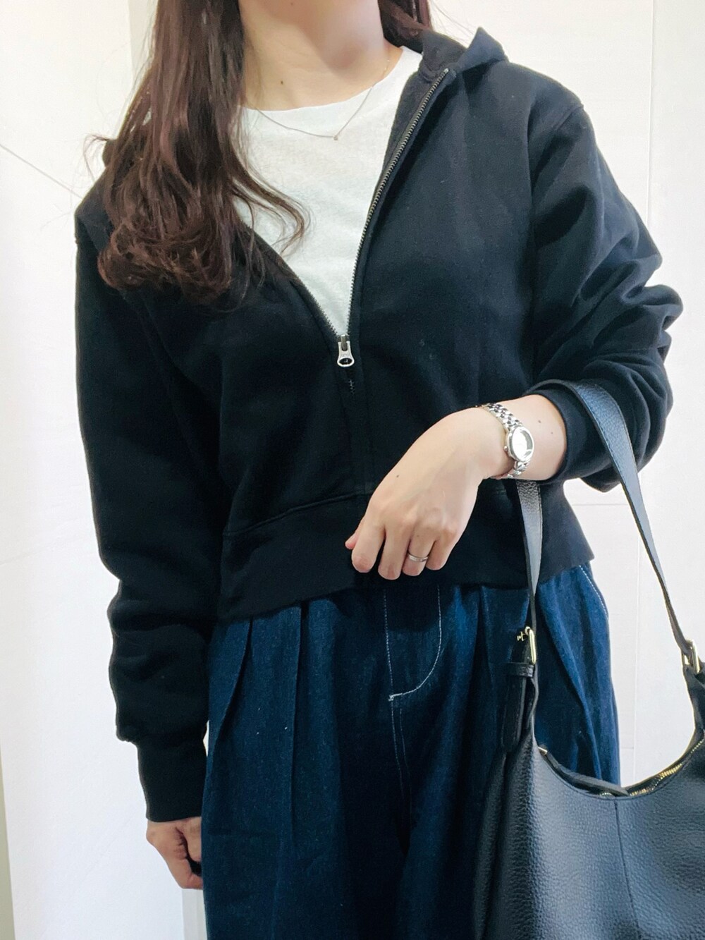 ブルー系のデニムパンツ、ホワイト系のスニーカー、ブラック系のショルダーバッグを着用したレディースの春コーディネートの4枚目の写真