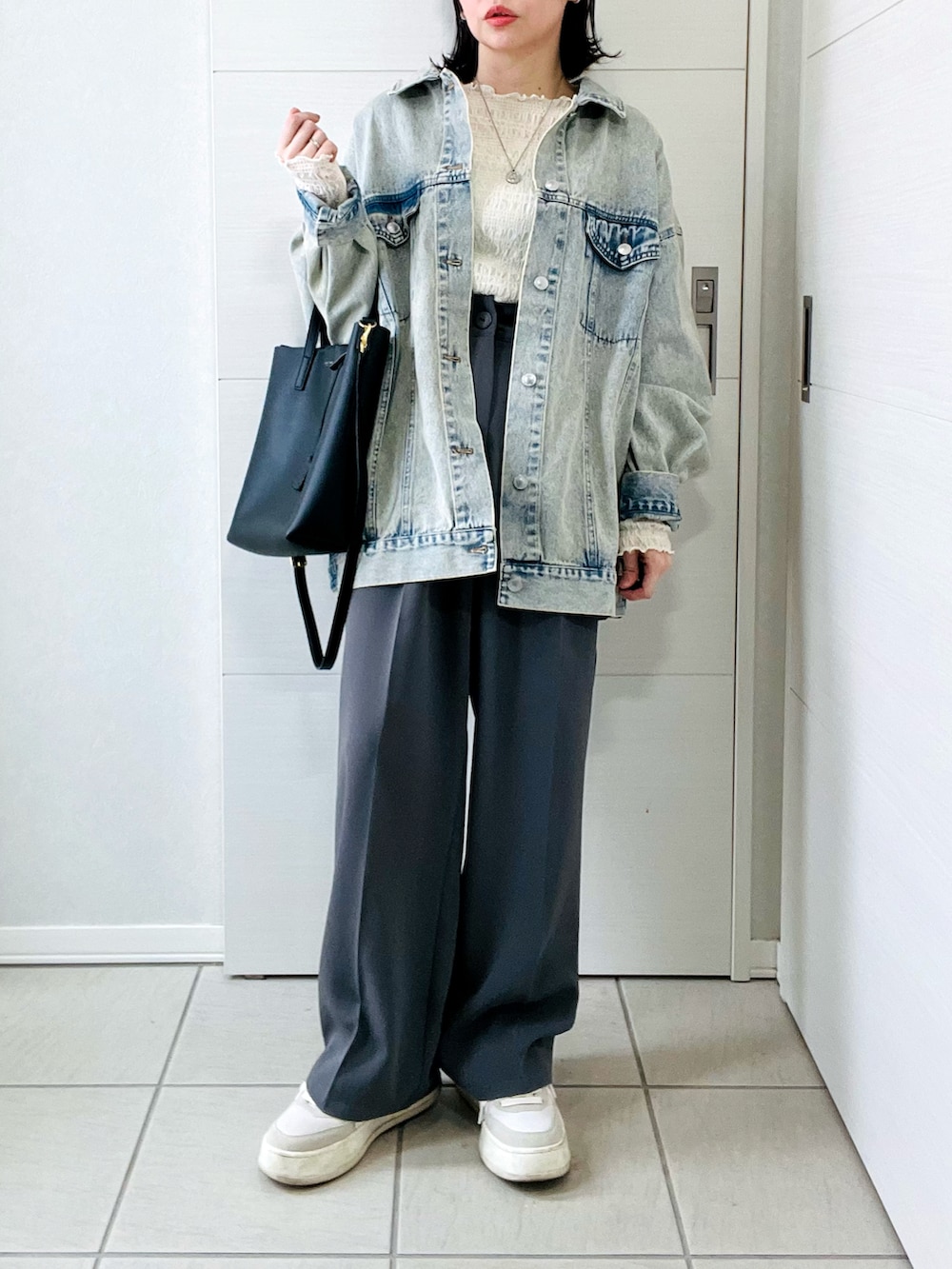 ブルー系のデニムジャケット、ホワイト系のTシャツ/カットソー、グレー系のスラックスを着用したレディースの春コーディネートの4枚目の写真